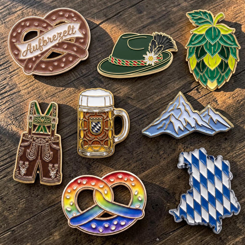 Bayerische Ansteck-Pins: Brezn, Trachtenhut, Hopfen, Lederhose, Maßkrug und Berge