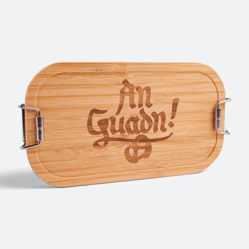Brotzeitbox mit Bambusdeckel und dem eingravierten Schriftzug „An Guadn!“ mit Brezn.