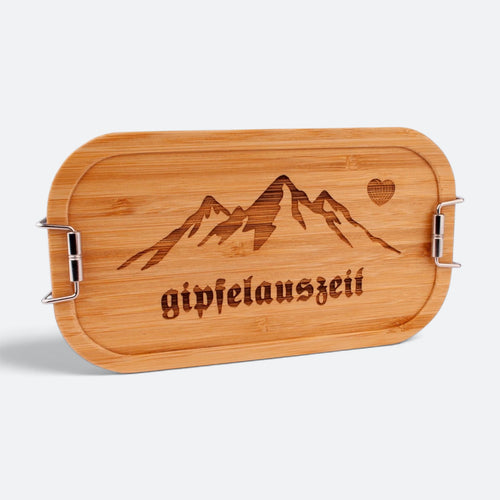Brotzeitbox mit Bambusdeckel, eingravierter Bergkette mit Herz und dem Schriftzug „gipfelauszeit“.