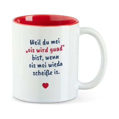 Weiße Tasse mit roter Innenseite und dem bairischen Spruch „Weil du mei ‚ois wird guad‘ bist, wenn ois moi wieda scheiße is.“ in Pinselschrift.