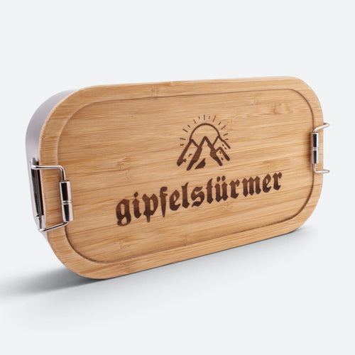 Brotzeitbox mit Bambusdeckel, eingravierten Bergen mit Sonne und dem Schriftzug „gipfelstürmer“.