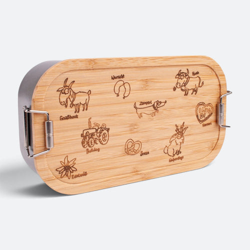 Brotzeitbox für Kinder mit Bambusdeckel, eingraviert sind Goaßbock, Kuah, Zamperl, Wolpertinger, Bulldog, Brezn, Wurscht, Herzerl und Edelweiß.