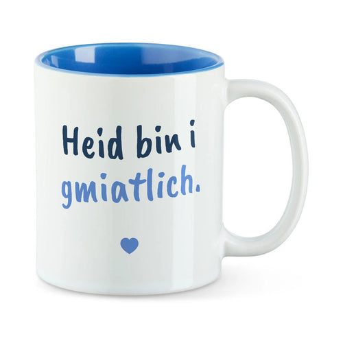 Weiße Tasse mit blauer Innenseite und dem bairischen Spruch „Heid bin i gmiatlich.“ in Pinselschrift.