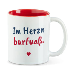 Weiße Tasse mit roter Innenseite und dem bairischen Spruch „Im Herzn barfuaß.“ in Pinselschrift.