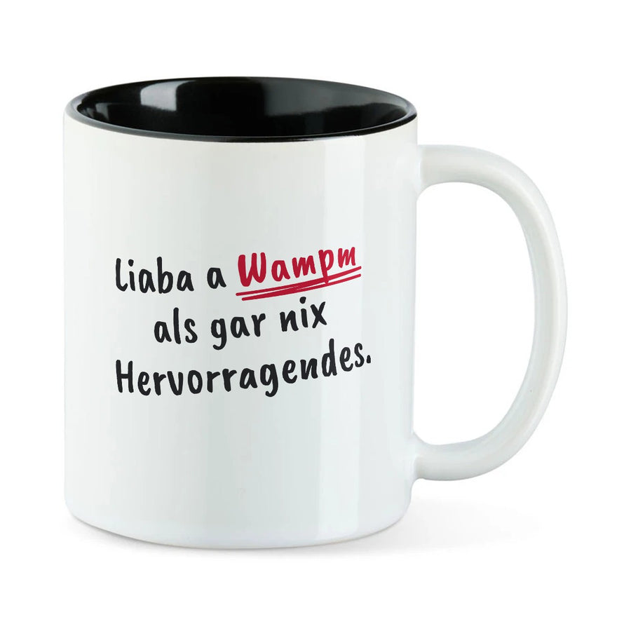 Weiße Tasse mit schwarzer Innenseite und dem bairischen Spruch „Liaba a Wampm als gar nix Hervorragendes.“ in Pinselschrift.