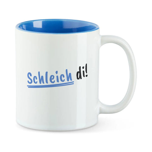 Weiße Tasse mit blauer Innenseite und dem bairischen Spruch „Schleich di!“ in Pinselschrift.